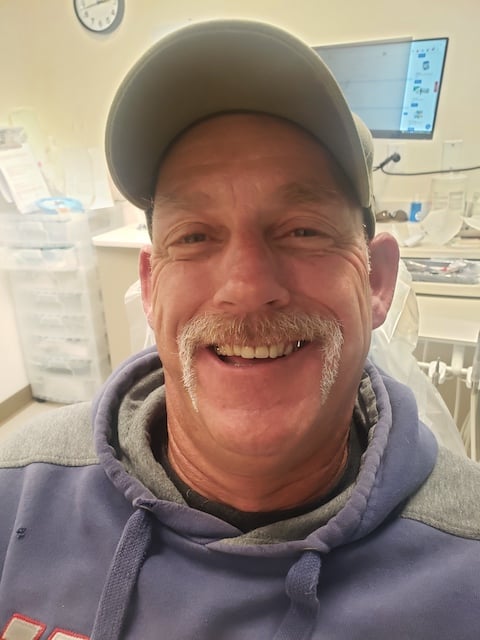 Patient smiling with front teeth replaced